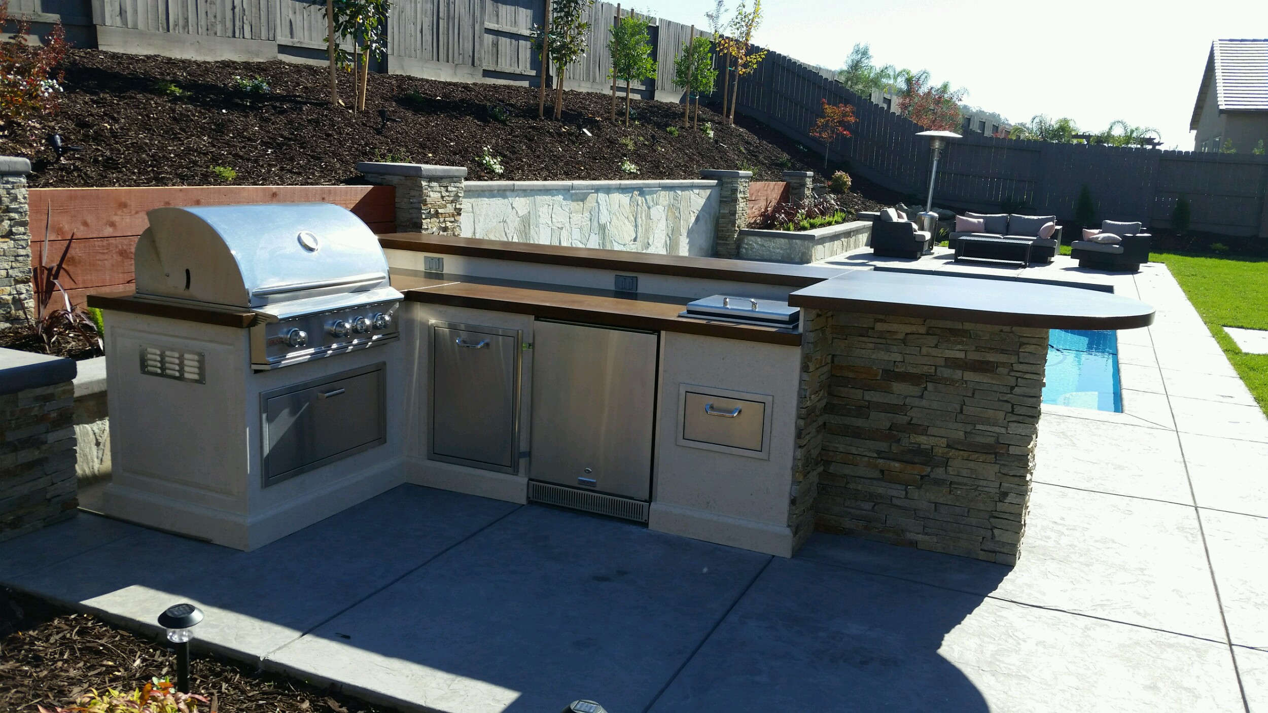 A patio heated up by an outdoor fire pit designed by Pacific Hearth & Home, Inc. in Rancho Cordova, CA